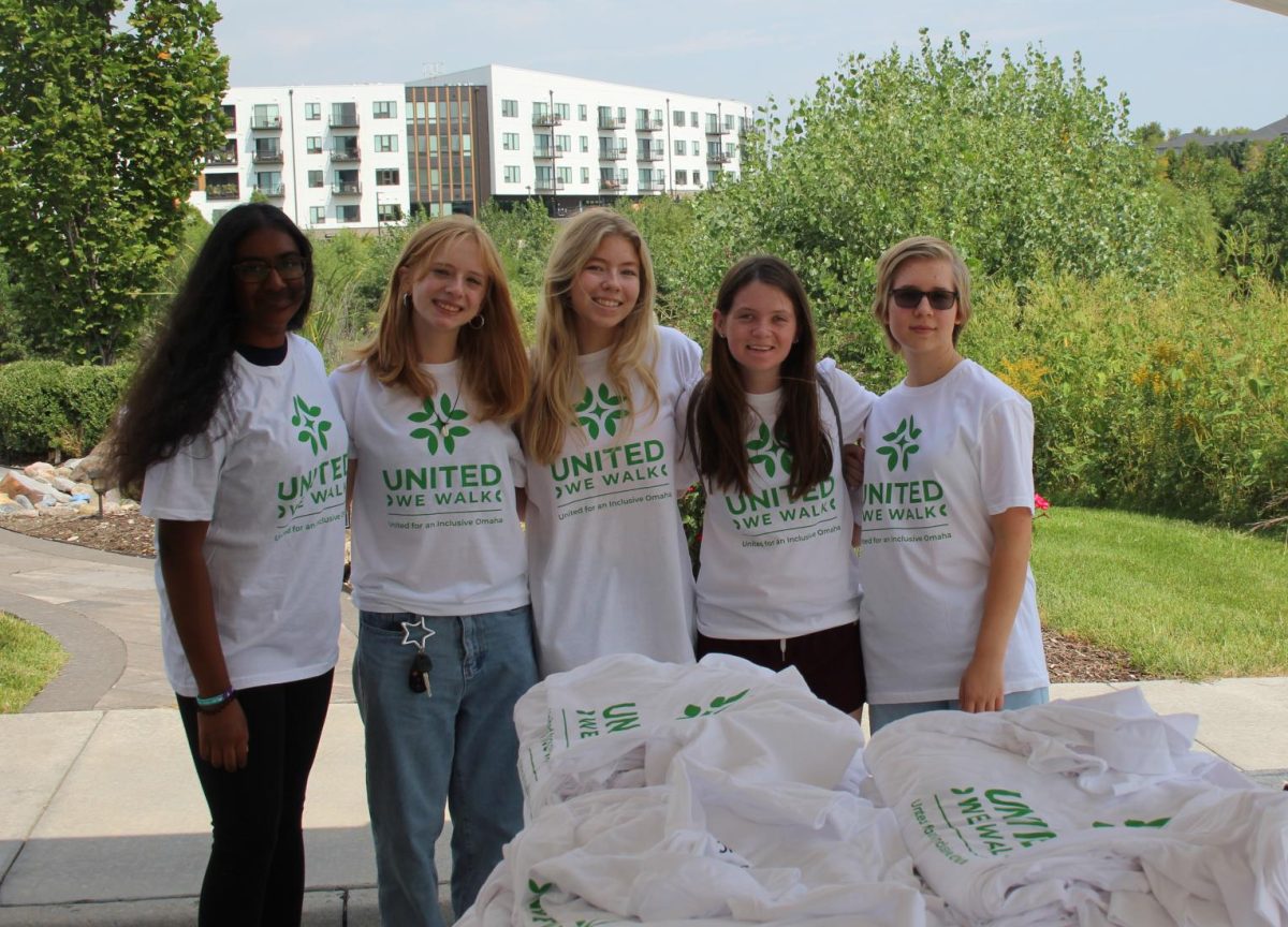 Folding shirts for volunteers was one of several different tasks that NHS students contributed to the annual United We Walk event at the Tri-Faith Initiative. 