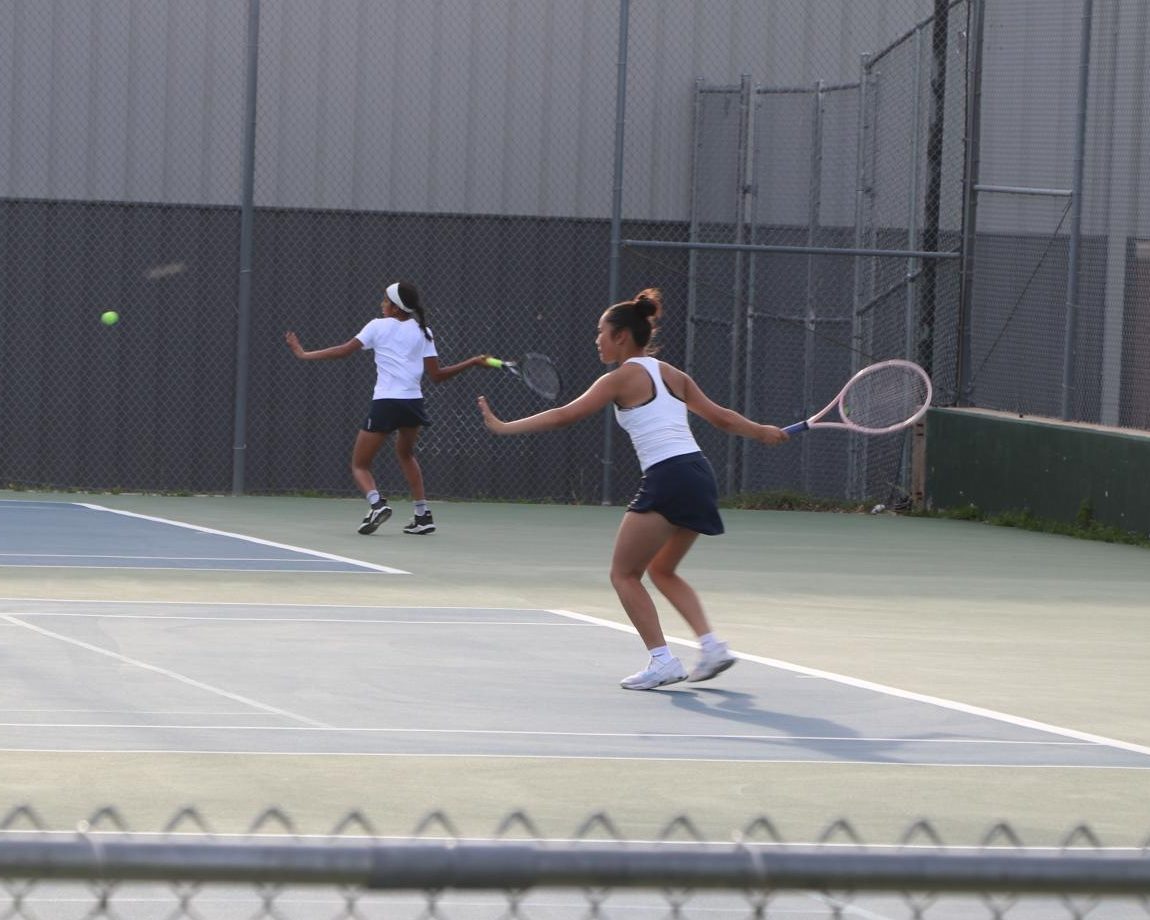 Tess Chen and Reeya Chundury synchronize forehands at Woods Tennis Center in Lincoln, NE. 